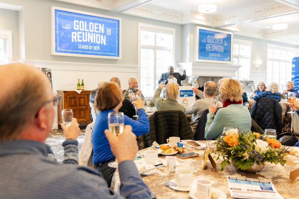 Event guests raising a glass with speaker at podium